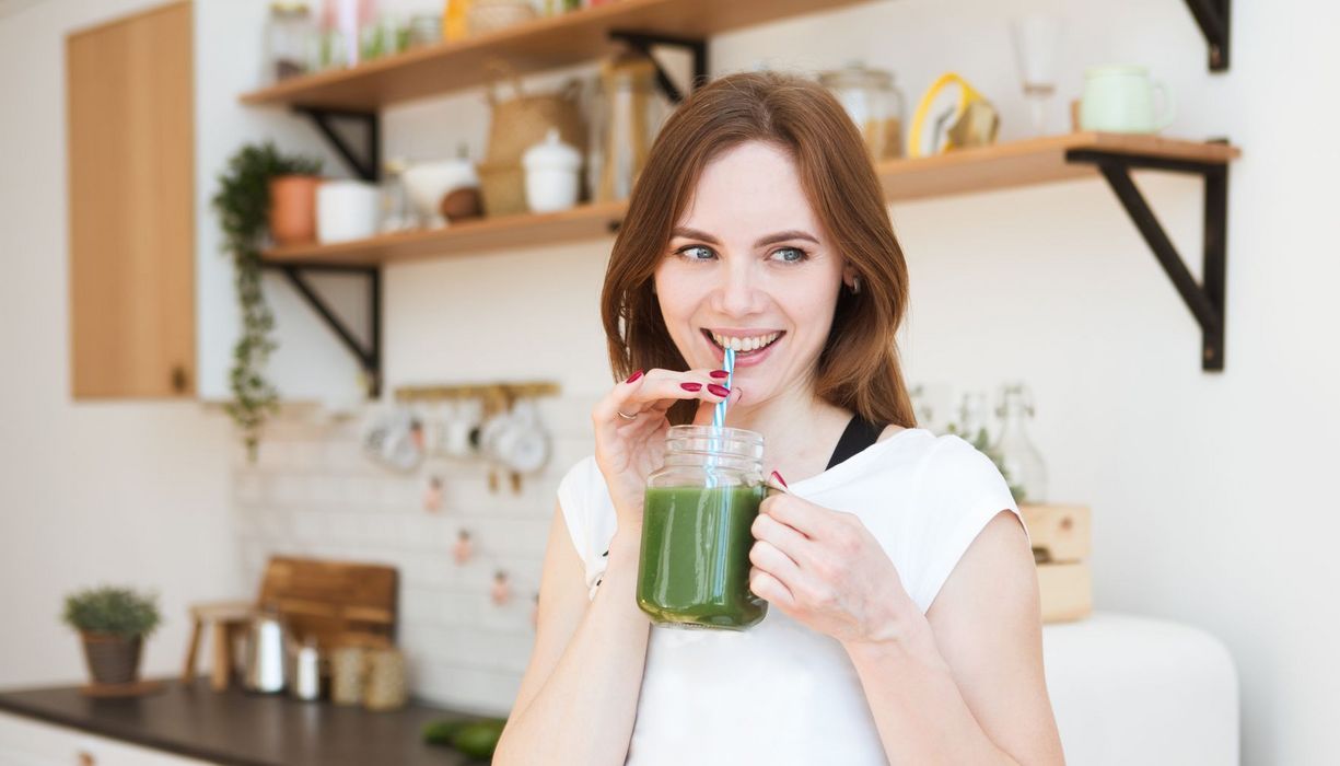 Frau trinkt einen grünen Smoothie.