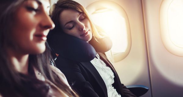 Zwei junge Frauen im Flugzeug, schlafen.