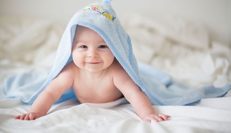 Baby mit Handtuch auf dem Kopf.