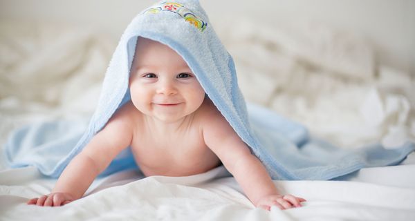 Baby mit Handtuch auf dem Kopf.