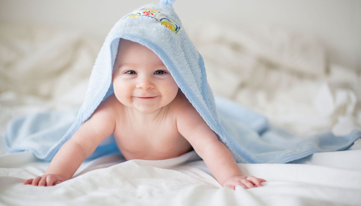 Baby mit Handtuch auf dem Kopf.