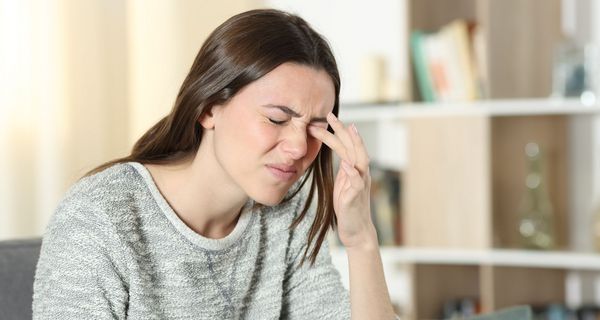 Junge Frau reibt sich die Augen.