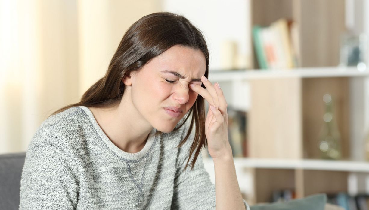 Junge Frau reibt sich die Augen.
