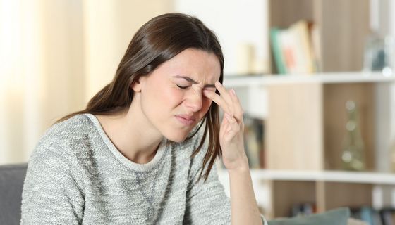Junge Frau reibt sich die Augen.
