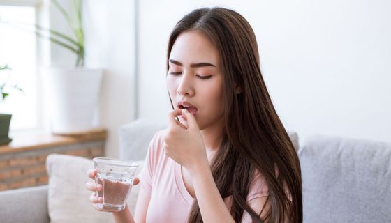 Eine Frau nimmt ein Medikament ein.