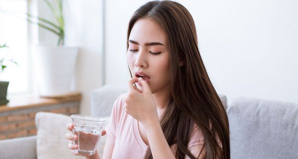 Eine Frau nimmt ein Medikament ein.