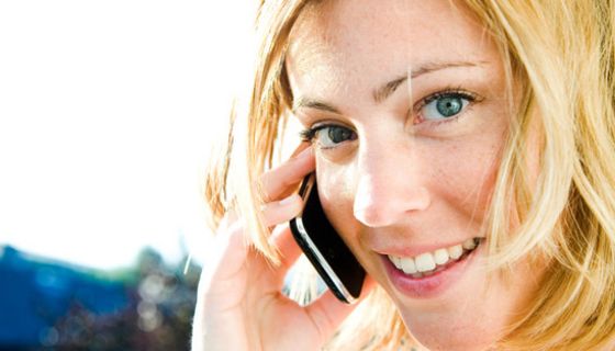 Junge Frau hält sich ein Handy ans Ohr