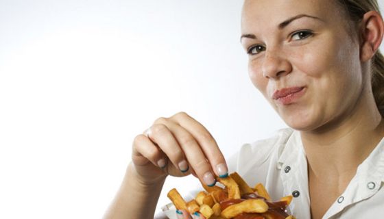 Frau isst Pommes Frites.