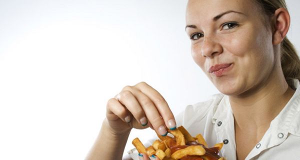 Frau isst Pommes Frites.