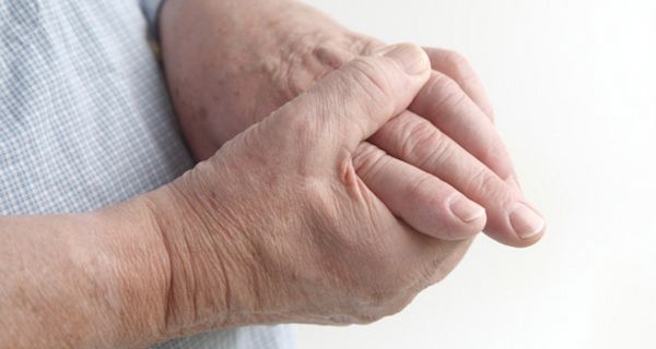Gicht-Patient betastet seine schmerzenden Hände