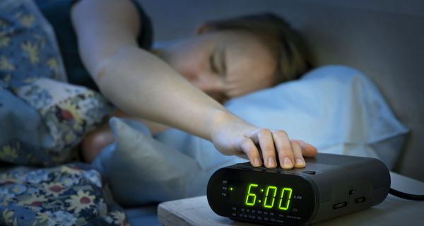 Junge Frau, drückt auf die Schlummertaste.