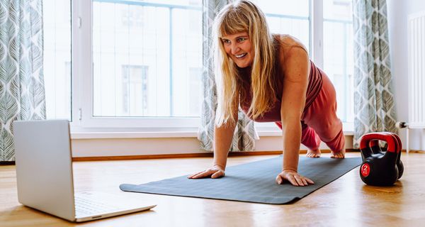 Übergewichtige Frau, macht Sport mit dem Laptop.