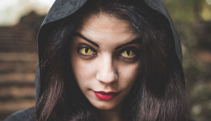 Frau mit gelben Kontaktlinsen, die ihre Augen geschlitzt aussehen lassen.