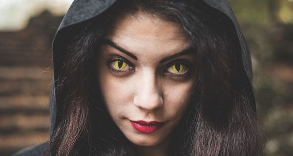 Frau mit gelben Kontaktlinsen, die ihre Augen geschlitzt aussehen lassen.