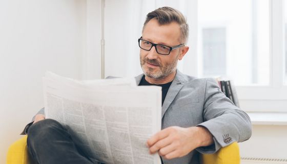 Mann, 50+, mit Brille liest Zeitung.