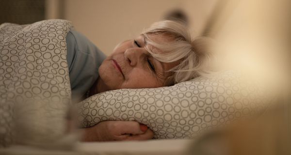 Ältere Frau, liegt im Bett und schläft.