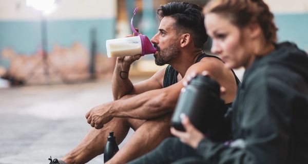 Ein sportliches Paar, dass sich ausruht und trinkt.