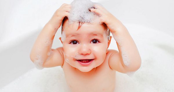 Kleinkind wäscht sich die Haare in der Badewanne.