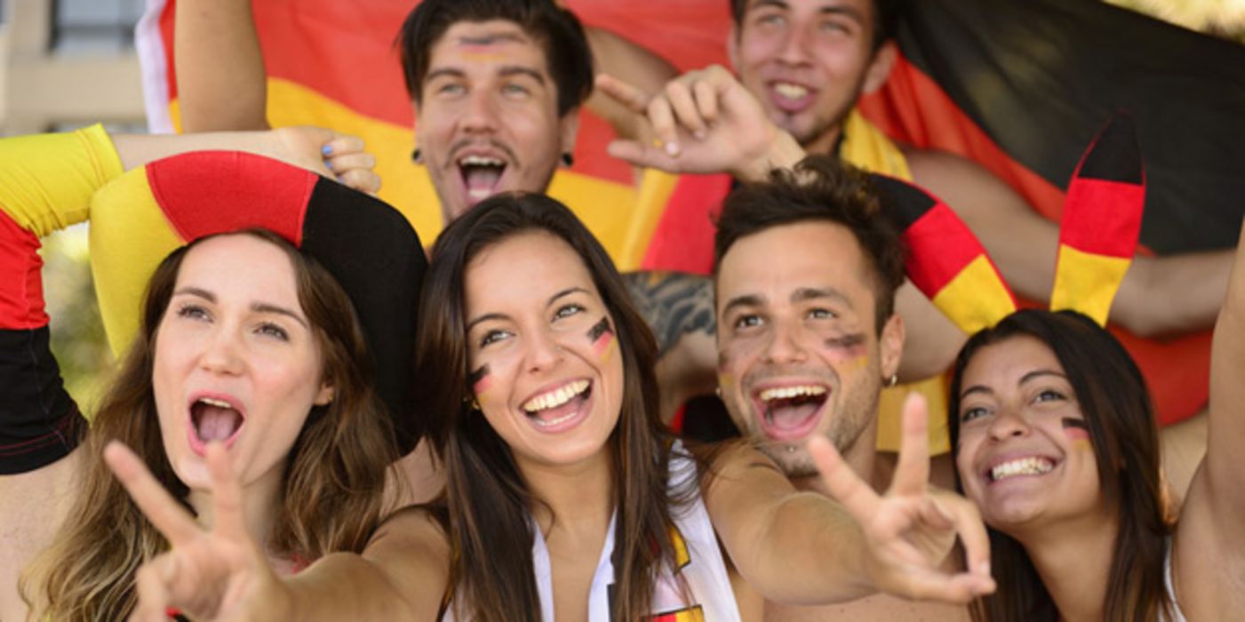 Eine Gruppe junger jubelnder und begeisterter deutscher Fußballfans.