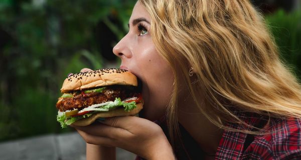 Frau beißt in Hamburger.