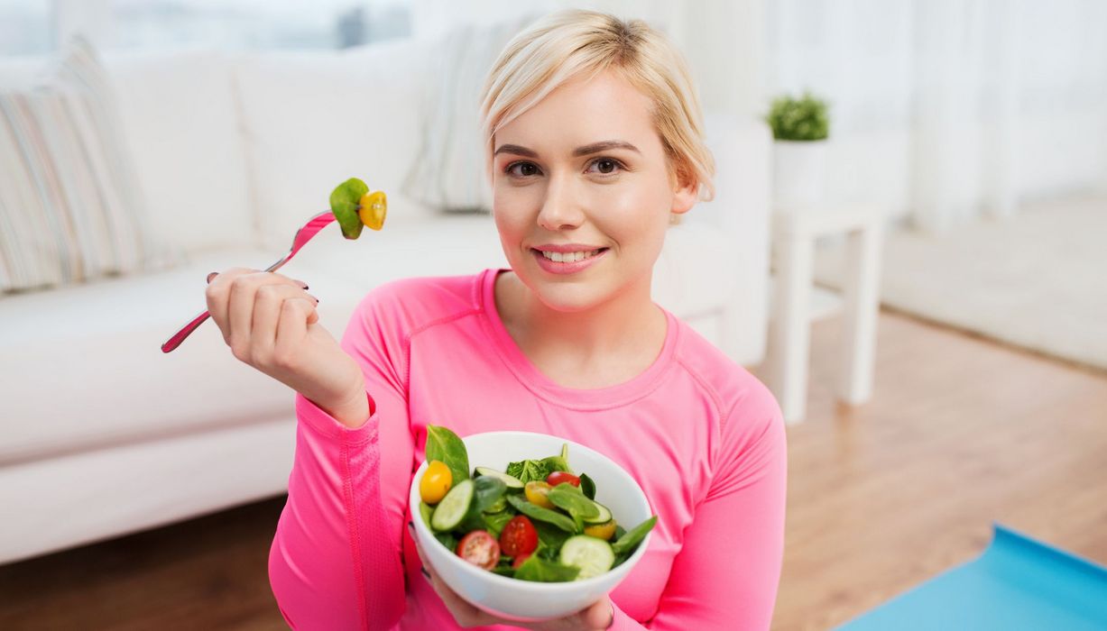Junge Frau isst einen Salat.
