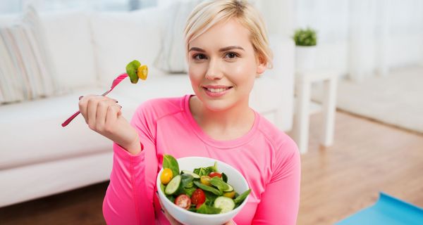 Junge Frau isst einen Salat.