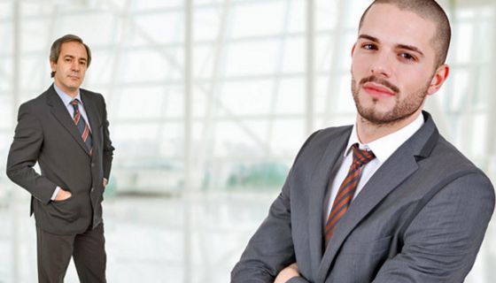 Jüngerer und älterer Geschäftsmann stehen sich einander gegenüber