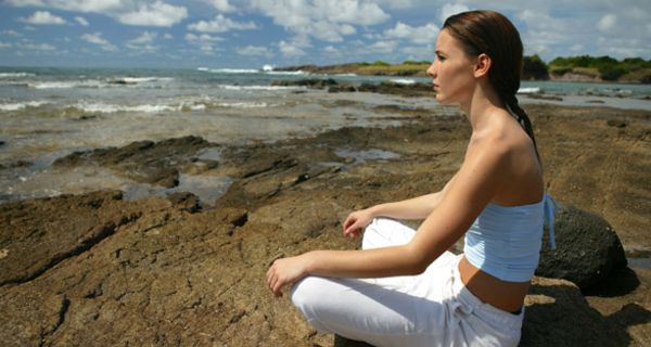 Meditierende Frau an der Küste