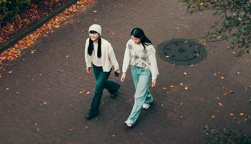 Zwei Frauen beim Spazierengehen in praktischer Alltagskleidung.