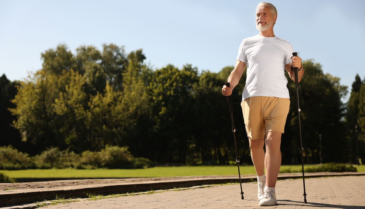Älterer Mann beim Nordic Walking