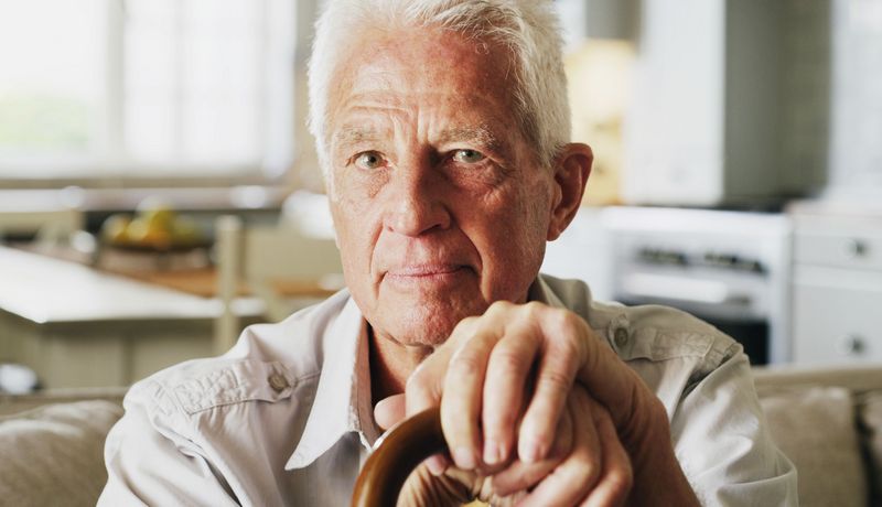 Älterer Herr schaut neutral mit undurchschaubarerer Mine in die Kamera.