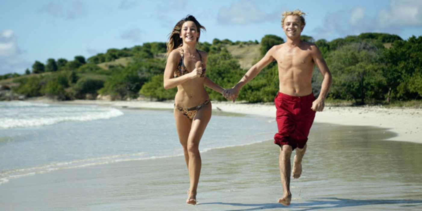 Junges Paar rennt am Strand.