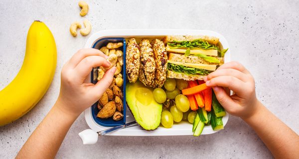 Brotdose mit gesunden, vegetarischen Lebensmitteln und Obst.