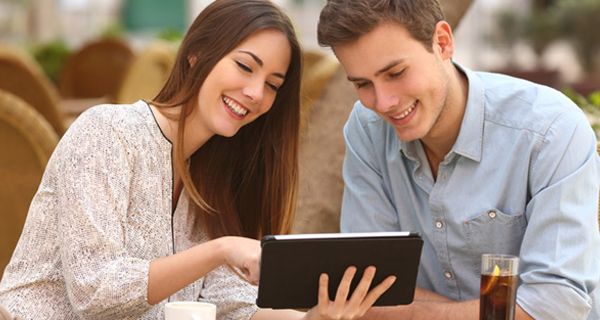 Junges, attraktives Paar im Café, schauen gemeinsam auf Tablet-PC