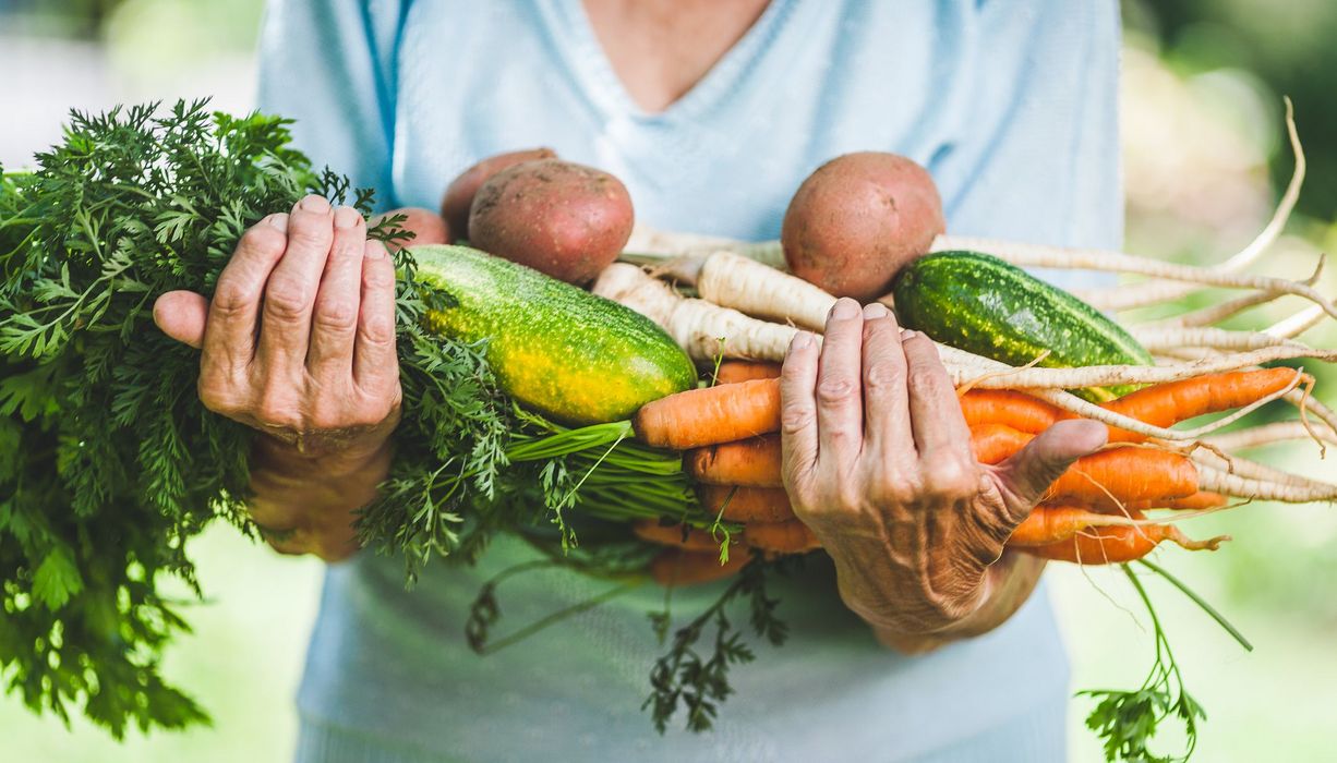 Frau, hält Gemüse in der Hand.