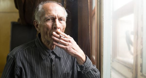 Älterer Mann, raucht eine Zigarette.
