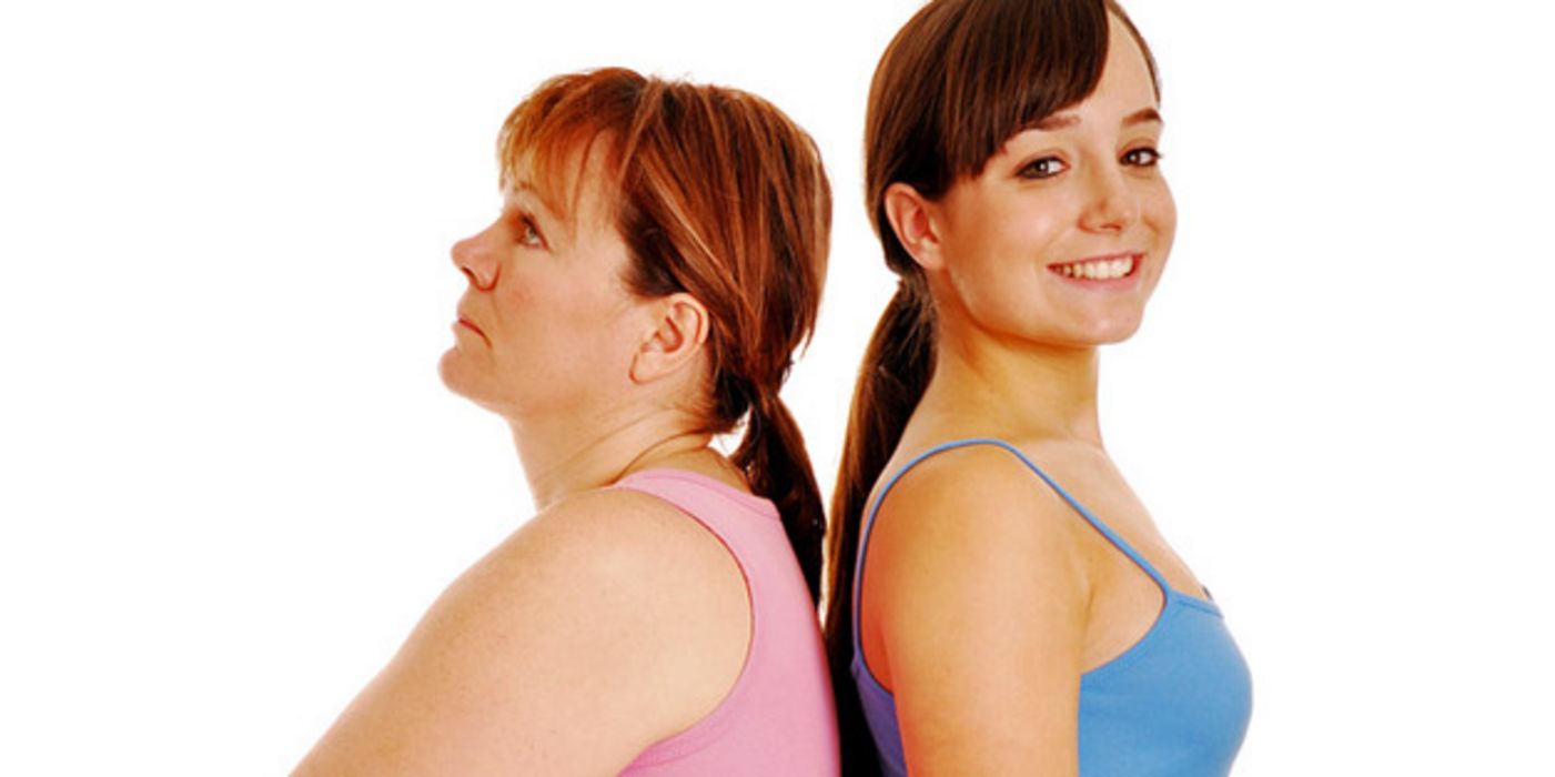 Eine schlanke und eine übergewichtige Frau stehen Rücken an Rücken.