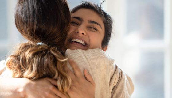 Zwei junge Frauen, umarmen sich.