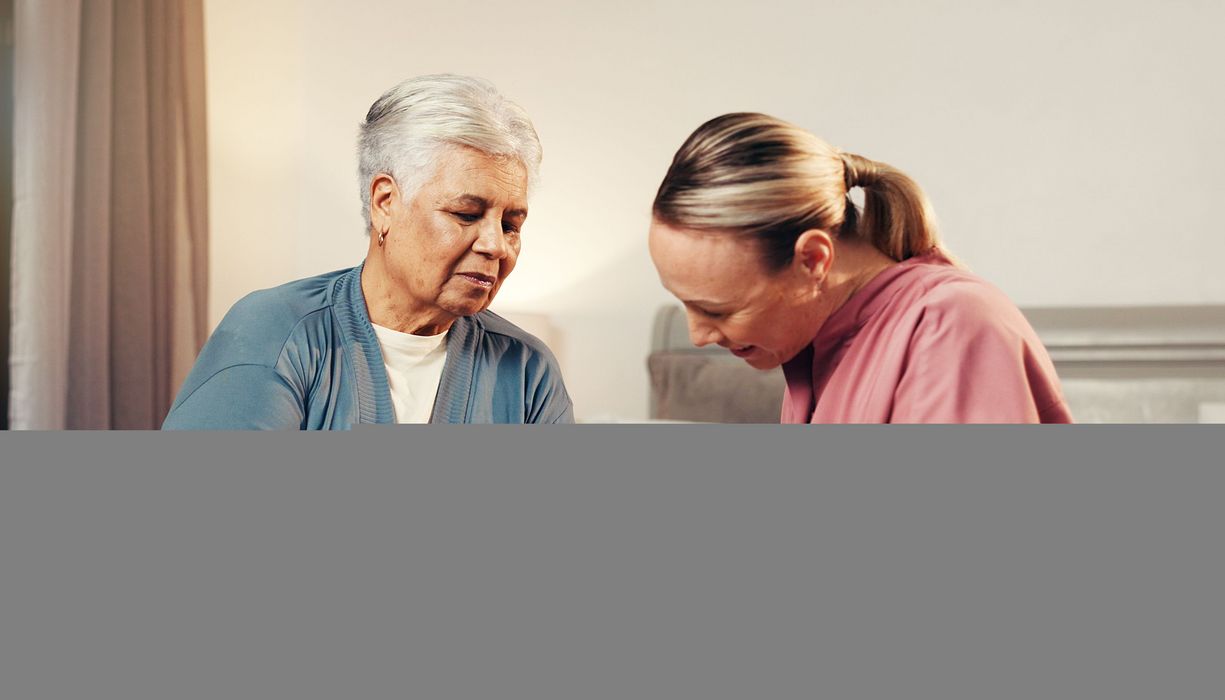 Pflegerin misst Frau den Blutzucker.