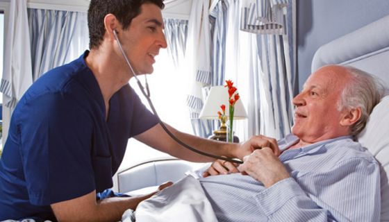 Arzt horcht das Herz eines älteren Patienten im Krankenhaus mit einem Stethoskop ab