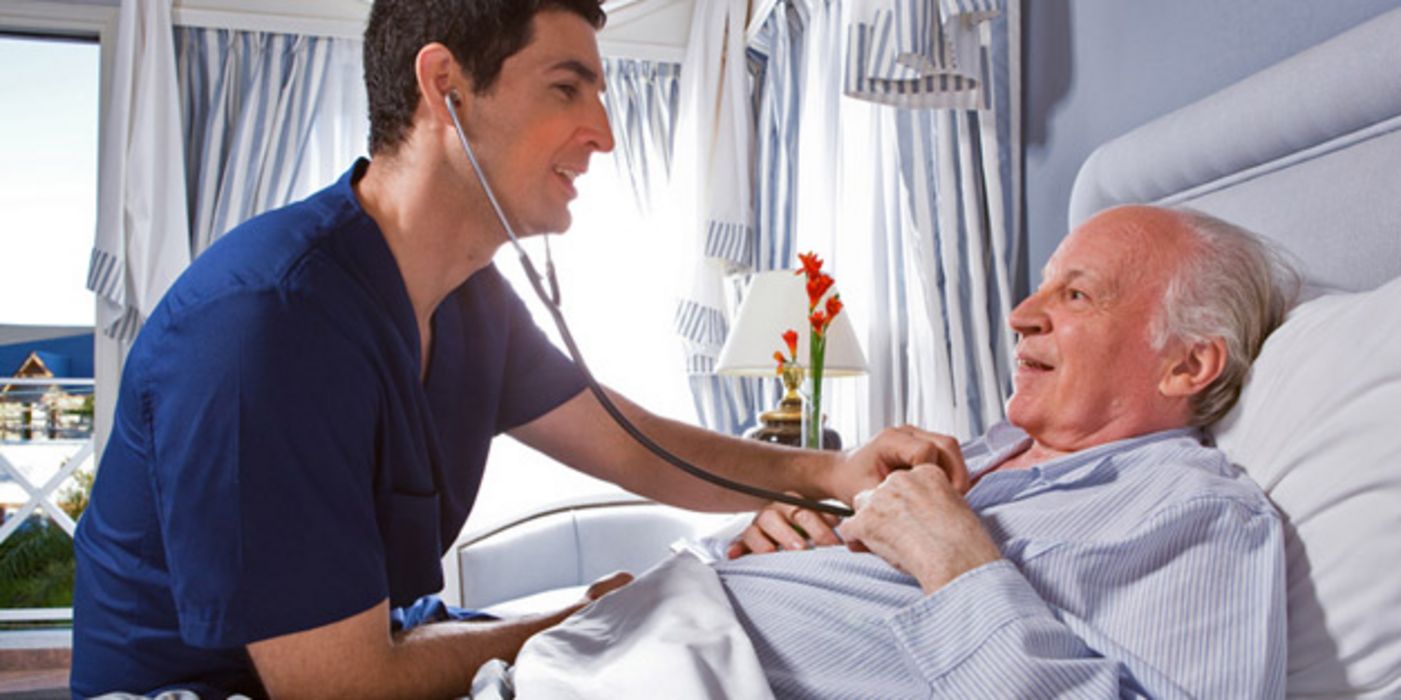 Arzt horcht das Herz eines älteren Patienten im Krankenhaus mit einem Stethoskop ab