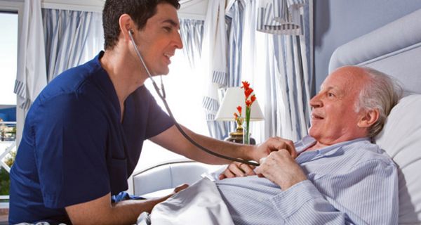 Arzt horcht das Herz eines älteren Patienten im Krankenhaus mit einem Stethoskop ab