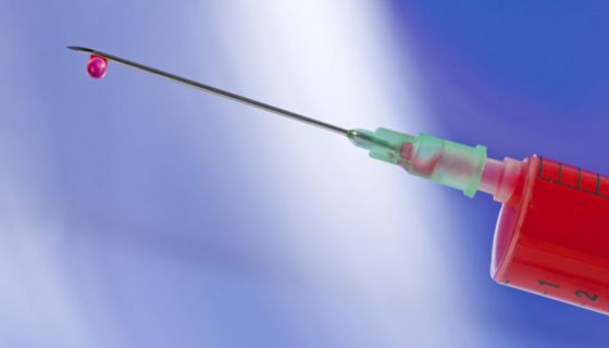 Spritze mit Blutstropfen am Kanülenende