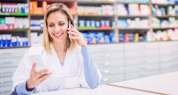 Freundliche Apothekerin telefoniert mit einem Kunden.