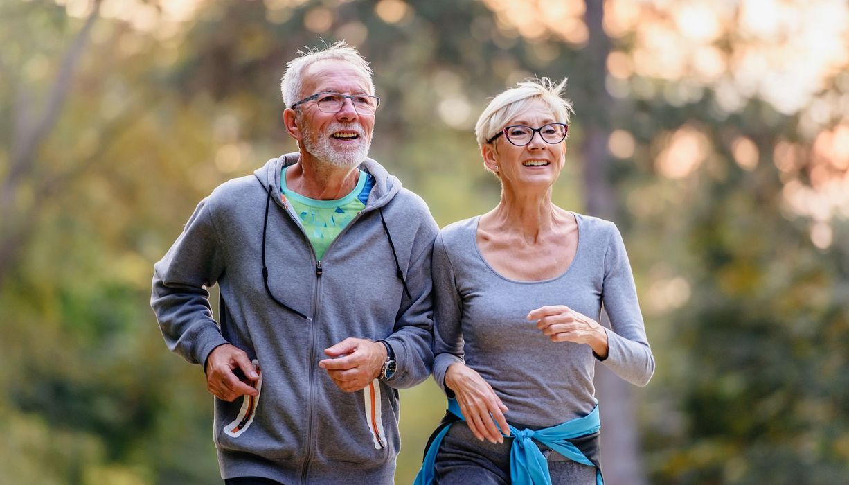 Senioren-Paar joggt im Wald