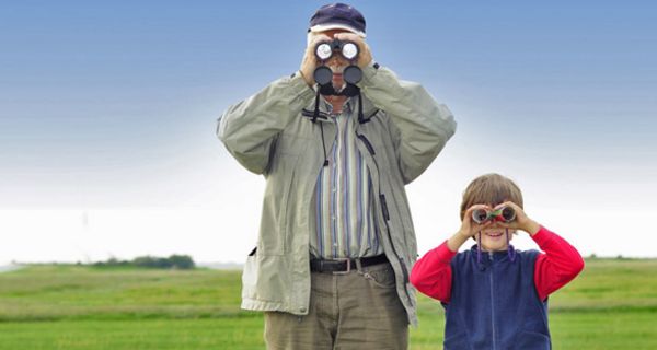 Großvater und Enkel schauen durch Ferngläser