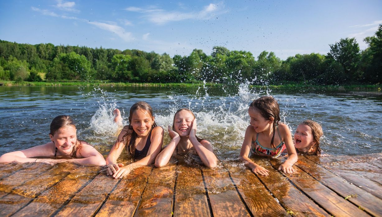 Kinder, planschen in einem Badesee.