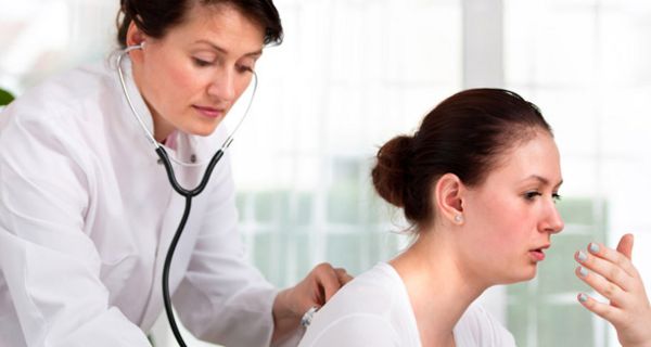 Ärztin hört hustende Patientin mit Stethoskop ab