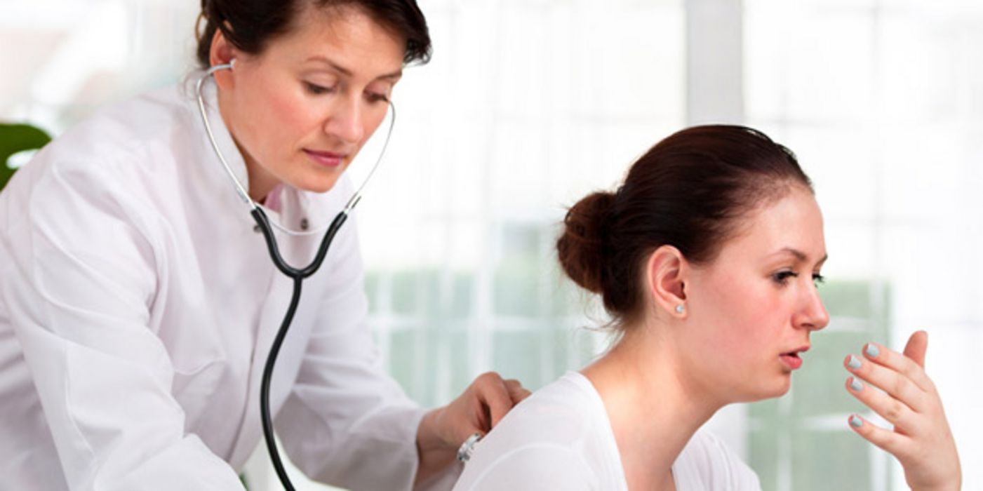 Ärztin hört hustende Patientin mit Stethoskop ab