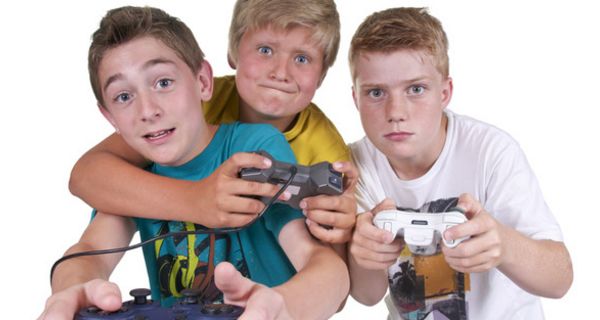 Drei Jungs mit Spielkonsolen und gebanntem Gesichtsausdruck